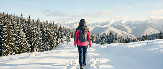 Randonneuse en veste d'hiver doublée polaire sur un sentier enneigé au lever du jour