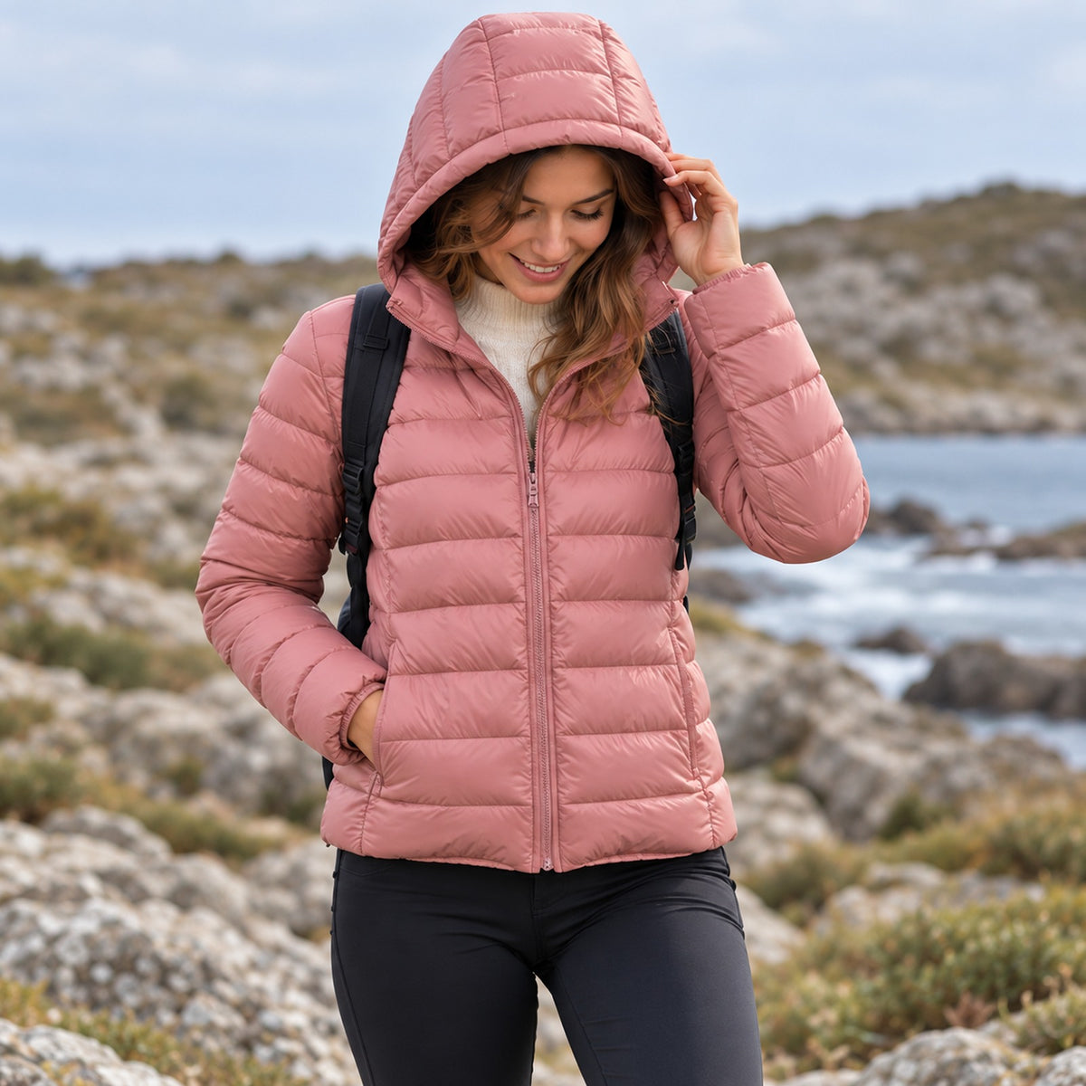 Doudoune randonnée compressible femme rose capuche relevée en montagne